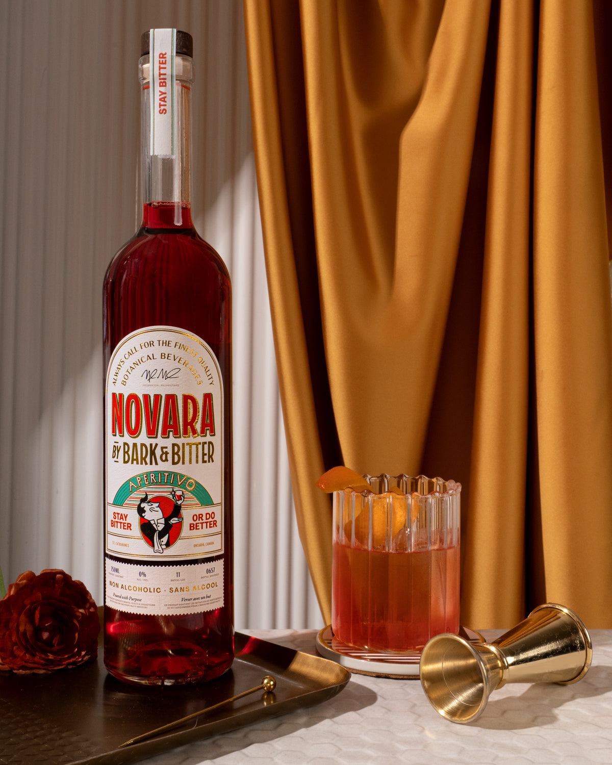 A bottle of Novara Aperitivo, a non-alcoholic Italian aperitif, next to a Negroni cocktail.